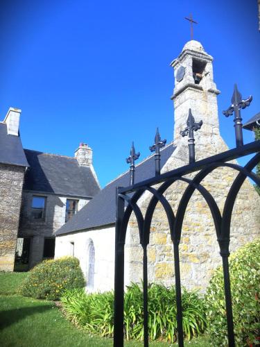 Une église avec une clôture noire devant elle dans l'établissement Manoir du Scluz-Prestigieux domaine vue mer, à La Terre du Pont