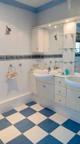 a bathroom with two sinks and a tiled floor at Traditional English house TravellerAwards2026 in Brighton & Hove