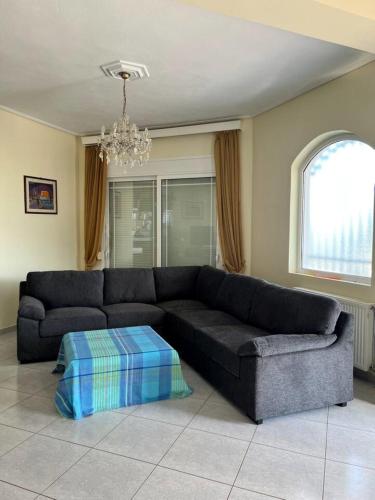 a living room with a black couch and a chandelier at Soros Seaside Villa in Kritharia