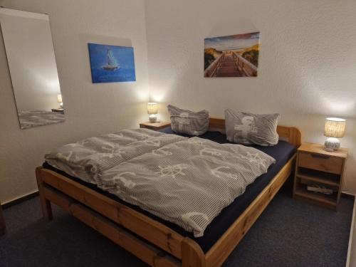 un letto in una camera con due comodini e due lampade di Ferienwohnung Seesternchen am Deich a Norden