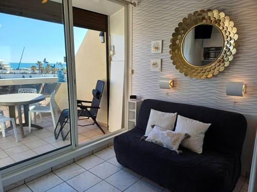 un salon avec un canapé et un miroir dans l'établissement Résidence Héliopolis Bâtiment E - studio 2 Pers. Héliopolis Bât. E MAE-4474, au Cap d'Agde
