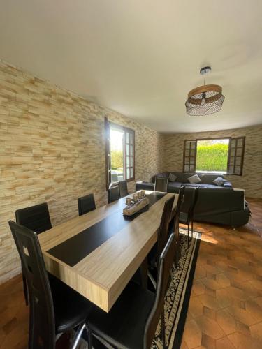 a living room with a table and a couch at BY NEPTUNE - La Maison Courtenay Piscine Privée, 4 Chambres in Courtenay
