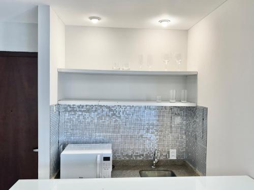 a bathroom with a sink and a tiled wall at Hotel São Paulo - Avenida Paulista in Sao Paulo