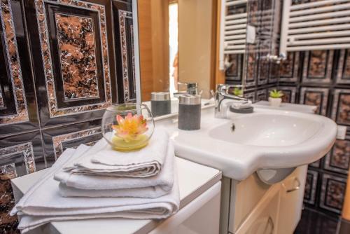 a bathroom with a sink and a bowl with a flower in it at S&P City Center Apartments in Kotor