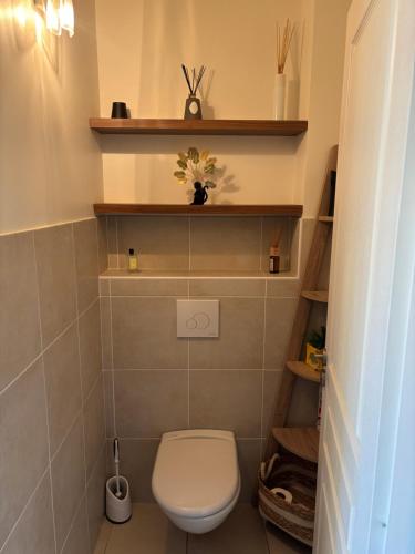 Elle comprend une petite salle de bains pourvue de toilettes et d'étagères. dans l'établissement Superbe T3 avec Grande Terrasses, à Ajaccio