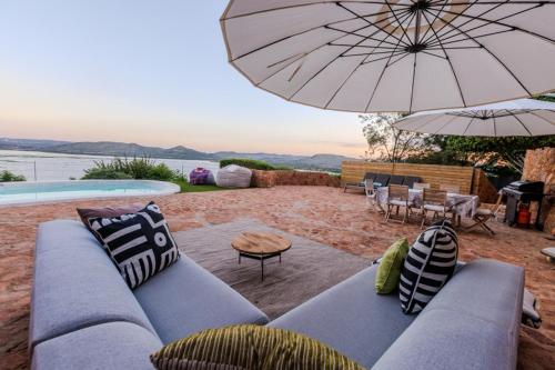 ハートビーズポートにあるEnso Botanico Boutique Wellness Villa, with an outside wood-fire Hot Tub in Kosmosのリビングルーム(ソファ、傘付)