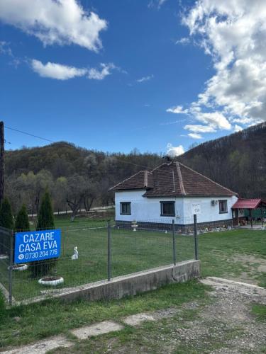 a white house with a sign in front of it at Casa Eva in Bucureşci