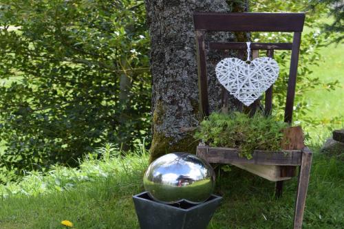 Un segno cardiaco su una sedia accanto a un albero. di Haus Winterberg a Schonach