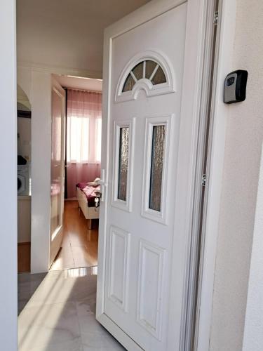 a white door in a hallway with a living room at Apartman Vedra in Umag
