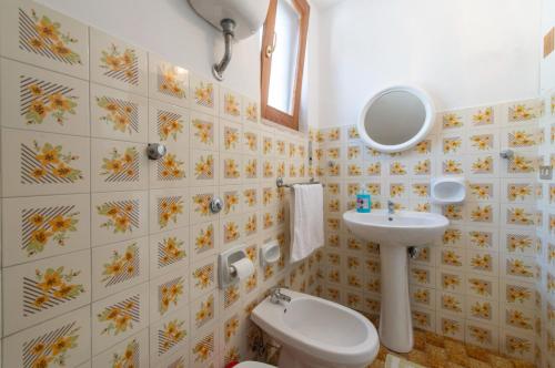a bathroom with a sink and a toilet and a mirror at Casa Ersilia in Agerola