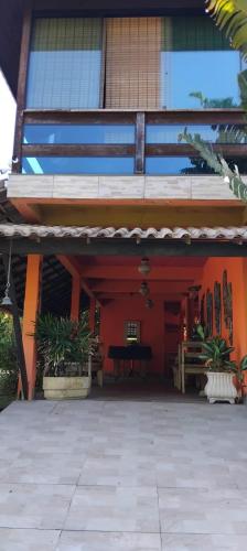 an outside view of a building with a red wall at Refugio Namastê - Sheila in São Pedro da Aldeia
