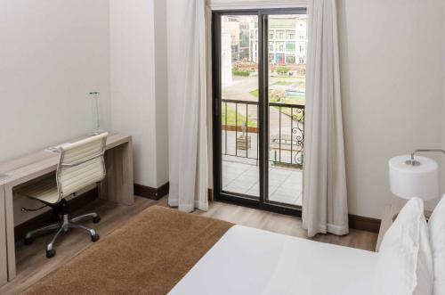 a bedroom with a bed and a desk and a window at Terrado Arturo Prat Iquique in Iquique