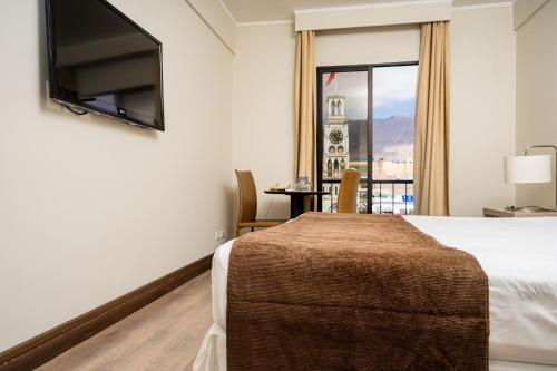 a hotel room with a bed and a window at Terrado Arturo Prat Iquique in Iquique