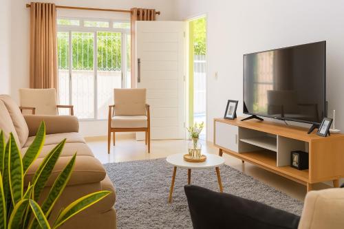 a living room with a couch and a tv at Casa em Aparecida 300m2 próximo ao Santuário Nacional in Aparecida