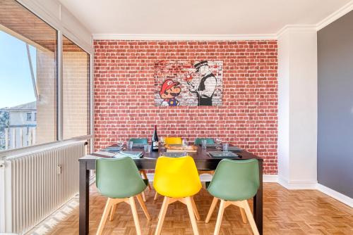 a dining room with a brick wall and a table and chairs at Le Super 8 - Free Parking, Fast WiFi, Calm - Top Angers, Families & Groupes in Angers