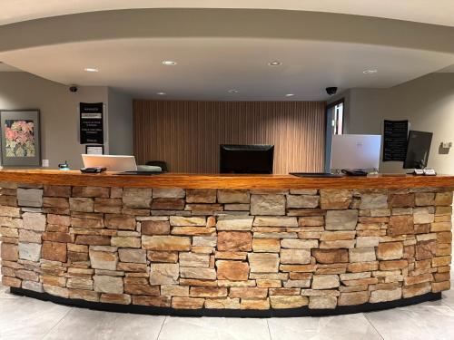 a stone bar in a lobby with two laptops at Anchor Inn and Suites in Campbell River