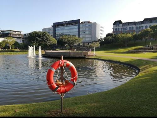 a life preserver in front of a pond in a park at Cozy Mellenial Umhlanga studio in Durban