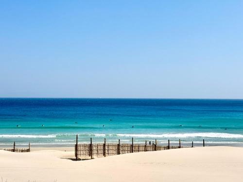 a beach with people in the water and the ocean at Sunset Villa Shirahama 5 min to the beach Pets OK in Shimoda