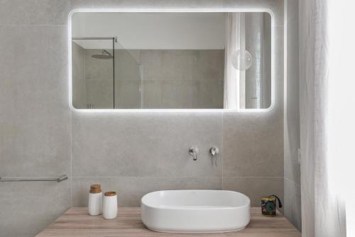 a bathroom with a white sink and a mirror at Terrazza Paradiso in Capoliveri