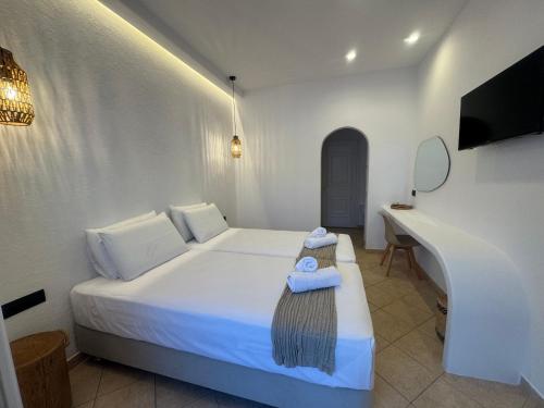a bedroom with a bed with a mirror and a desk at Eleni's Rooms in Antiparos Town