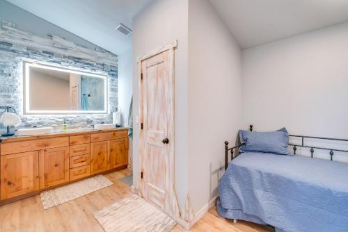 a bedroom with a bed and a sink and a mirror at Steps to Shore Family Beach Getaway in Westport in Westport