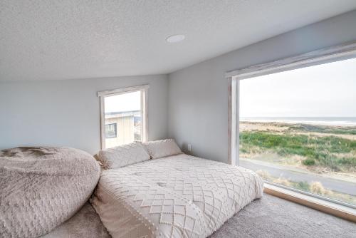 a bedroom with a bed and a large window at Steps to Shore Family Beach Getaway in Westport in Westport