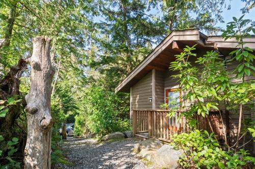 a cabin in the woods next to a tree at The Cabins at Terrace Beach in Ucluelet