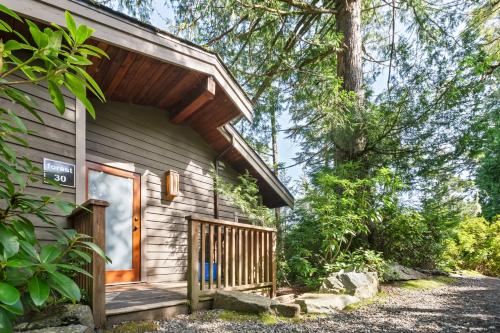 a log cabin with a porch and a door at The Cabins at Terrace Beach in Ucluelet
