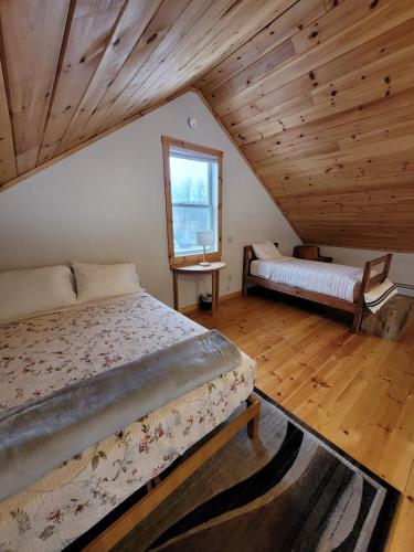 a bedroom with a bed and a window in a attic at Barn Cottage close to Smugglers Notch in Cambridge