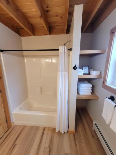 a walk in shower in a bathroom with wooden ceilings at Barn Cottage close to Smugglers Notch in Cambridge