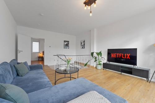 a living room with a blue couch and a tv at Charmante Design-Apartments in Top Lage - Nähe Altstadt - Parkplätze - Netflix in Bad Kreuznach