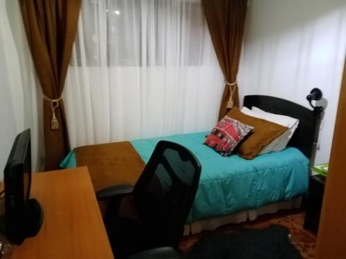 a room with a bed and a table and a table and chairs at Departamento en playa blanca in Antofagasta