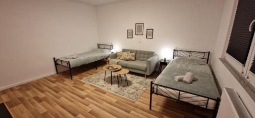 a living room with two beds and a couch at Bella - Zwischen Arena & Zoo stilvolle Unterkunft mitten in Gelsenkirchen-Schalke in Gelsenkirchen