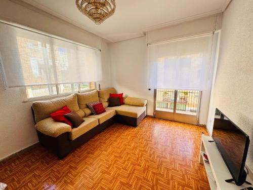 a living room with a couch and two windows at Apartamento centro de Nájera in Nájera
