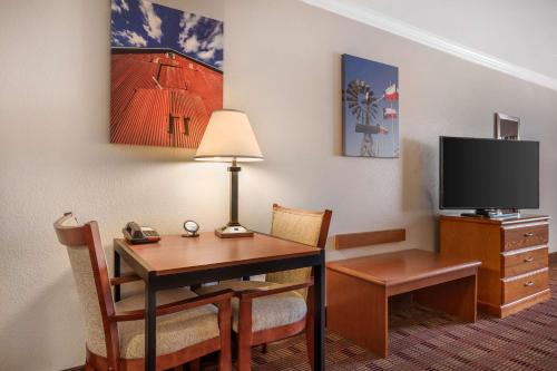 a hotel room with a desk and a tv at Best Western Club House Inn & Suites in Mineral Wells