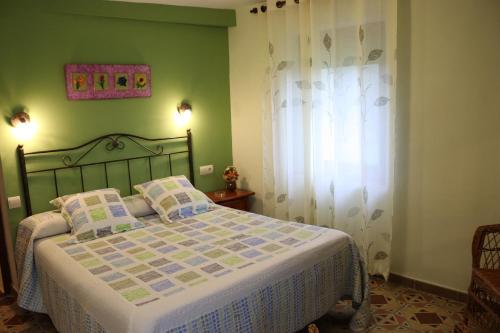 una camera da letto con un letto con una parete verde di La Torreta a Gerbe