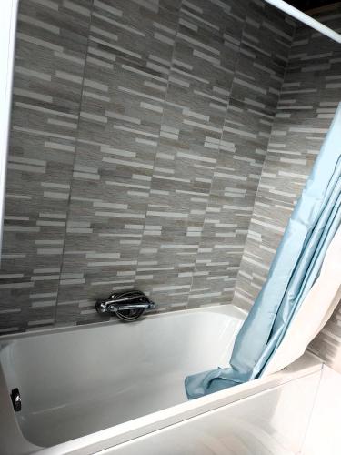 d'une baignoire avec du carrelage et une fenêtre. dans l'établissement hébergement Mézéozorn, à Plouguerneau