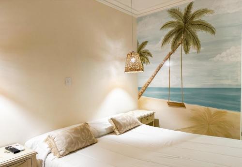 サンタ・マルタにあるHotel Valladolidのベッドルーム1室(ヤシの木の壁画のあるベッド1台付)