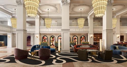 a lobby with chairs and tables and chandeliers at The Gunter Hotel San Antonio Riverwalk in San Antonio