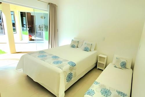 a bedroom with two beds and a window at Bosque do Itaoca - Beira do Rio, Lago, Mata Nativa in Guararema