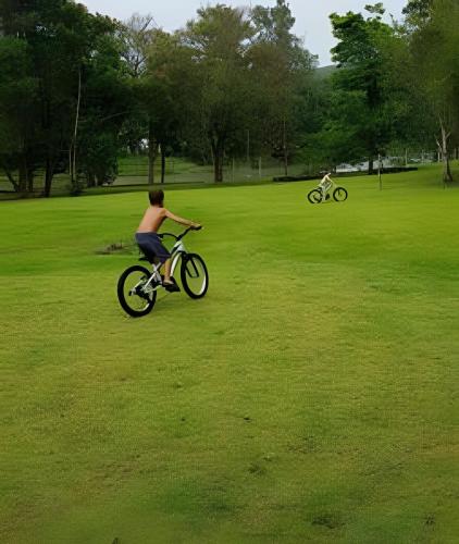 a young man riding a bike in a park at Bosque do Itaoca - Beira do Rio, Lago, Mata Nativa in Guararema