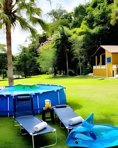 a pool table with two chairs and a trampoline at Bosque do Itaoca - Beira do Rio, Lago, Mata Nativa in Guararema
