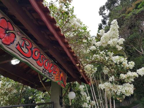 a sign for a restaurant with white flowers at Bosque do Itaoca - Beira do Rio, Lago, Mata Nativa in Guararema
