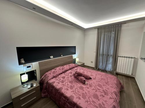 a bedroom with a large bed with a pink blanket at Alloggio Nola - casa e box auto in Nola