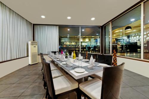 a dining room with a long table and chairs at The Fern Residency Rajkot in Rajkot