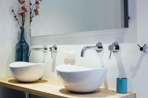 a bathroom with two white sinks on a counter at Appartement Aan de Veste in Enkhuizen