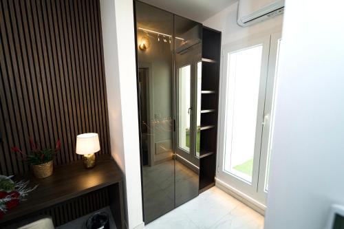 a bathroom with a glass walk in shower next to a window at Valesium Suite in Lecce