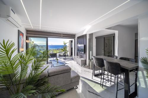 ein Wohnzimmer mit einer Couch und einem Tisch und Stühlen in der Unterkunft HiddenGems Residences 202 - The LXR Penthouse - Pool & Beach Steps in Paphos City