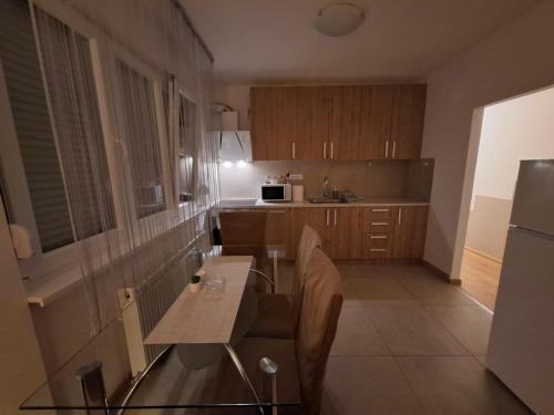 a small kitchen with a table and a refrigerator at Apartman Palma in Belgrade