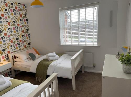 a bedroom with two twin beds and a window at High Trees in Chichester